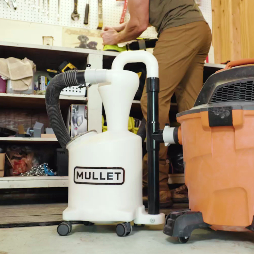 Woodworker with Mullet Tools High-Speed Cyclone Dust Collector connected to shop vacuum